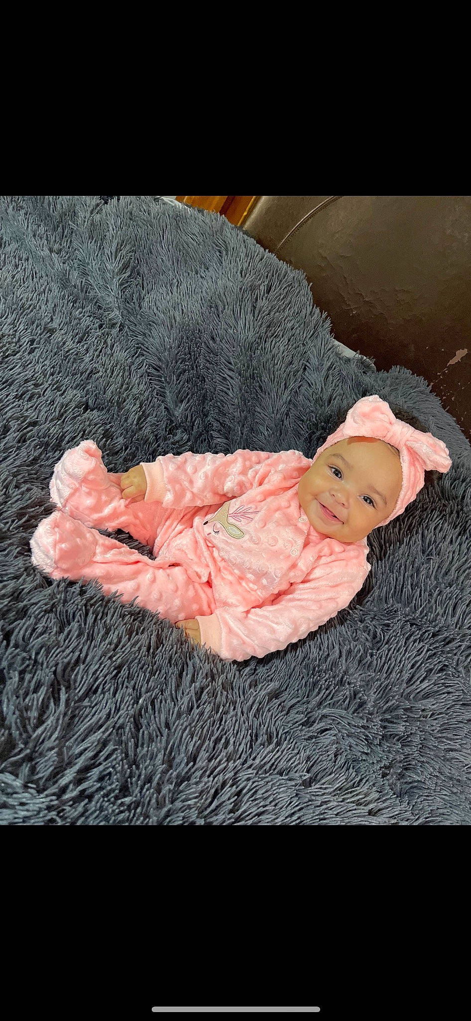 Alora is registered to the contest to win money with this photo: baby, baby_products, baby_toddler_clothing, cheek, child, comfort, fashion_accessory, flooring, fur, gesture, happy, headwear, linens, magenta, peach, person, sitting, sleeve, toddler, wood