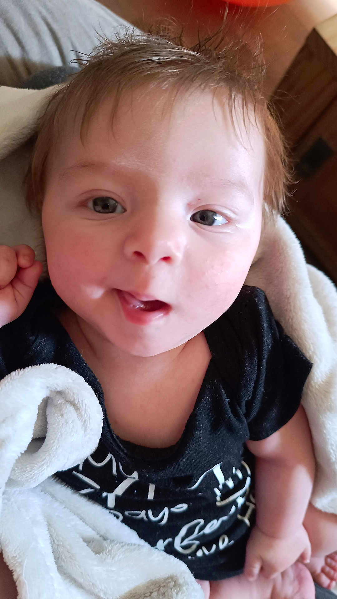 Noé participe au concours pour gagner de l'argent avec cette photo : baby, infant, child, face, eyes, mouth, tongue, hair, blanket, onesie, clothing, closeup, portrait, indoors, skin, smile, hand, towel, cozy, happy