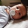 Noé participe au concours pour gagner de l'argent avec cette photo : baby, infant, pacifier, pacifier_clip, face, eye, blanket, lying_down, close_up, portrait, onesie, newborn, cute, sleepy, hair, skin, indoor, radiator, soft_texture, mouth