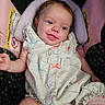 baby, infant, child, smiling, tongue_out, portrait, car_seat, pink, onesie, ruffles, socks, seated, indoors, close_up, face, eyes, hair, patterned_clothing, happy, photograph