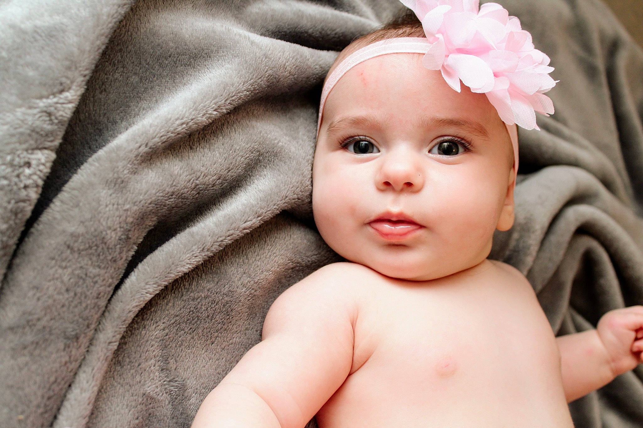 Hanna participe au concours pour gagner de l'argent avec cette photo : artificial_flower, baby, baby_toddler_clothing, barechested, cheek, chest, child, costume_accessory, eyelash, hair_accessory, headband, headpiece, headwear, iris, lip, muscle, person, petal, photography, pink