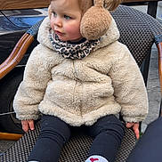 Leyna participe au concours pour gagner de l'argent avec cette photo : toddler, child, earmuffs, winter_jacket, scarf, white_sneakers, heart_socks, outdoor, chair, woven_chair, street, curious, cute, fashion, warm_clothing, daylight, casual, sitting, young_child, portrait