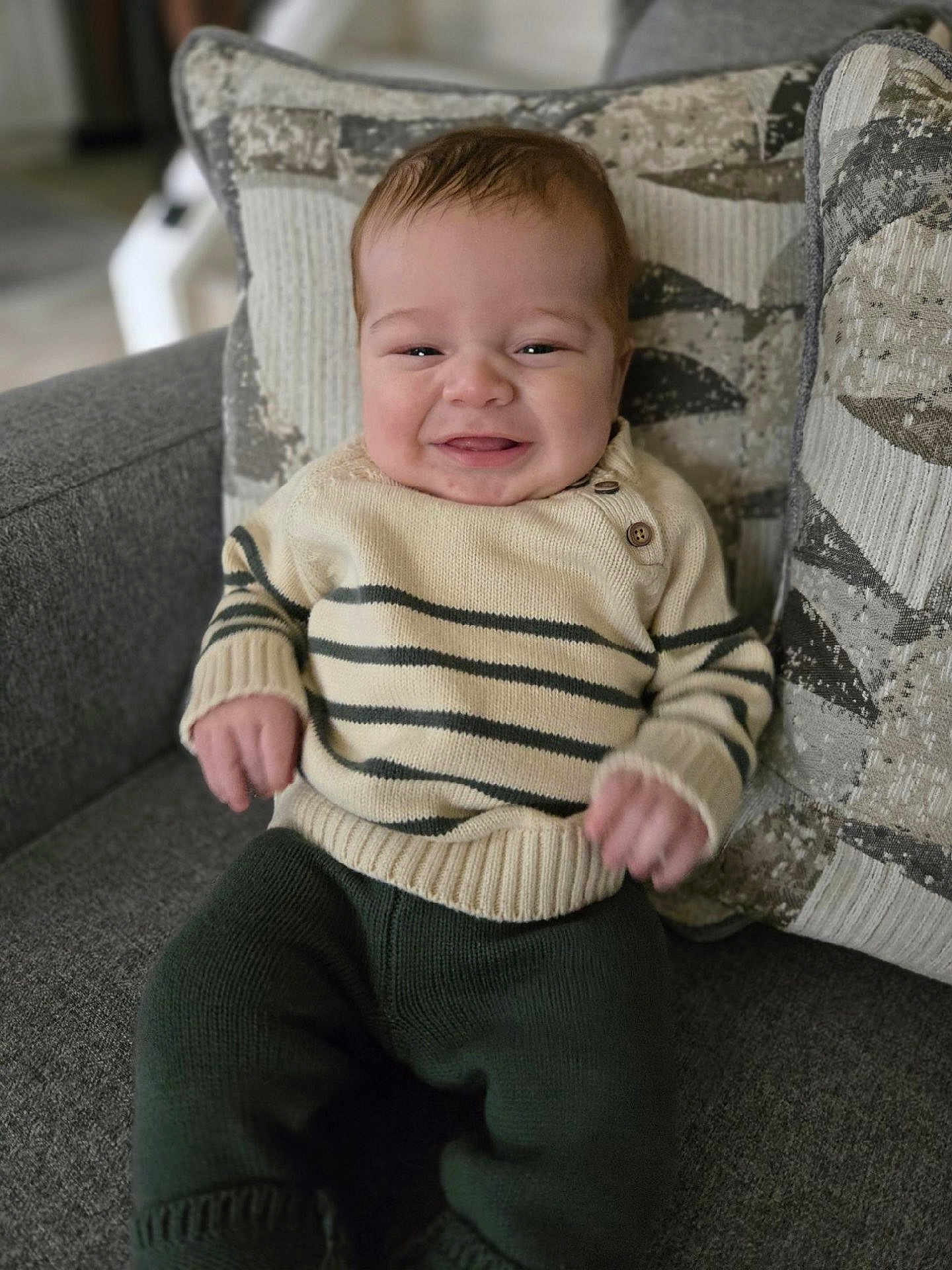 Lucas joined the competition — help win amazing prizes! baby, child, smile, sweater, pants, couch, pillow, indoor, knitwear, happy, face, person, seated, cozy, home, infant, cute, portrait, young, comfort