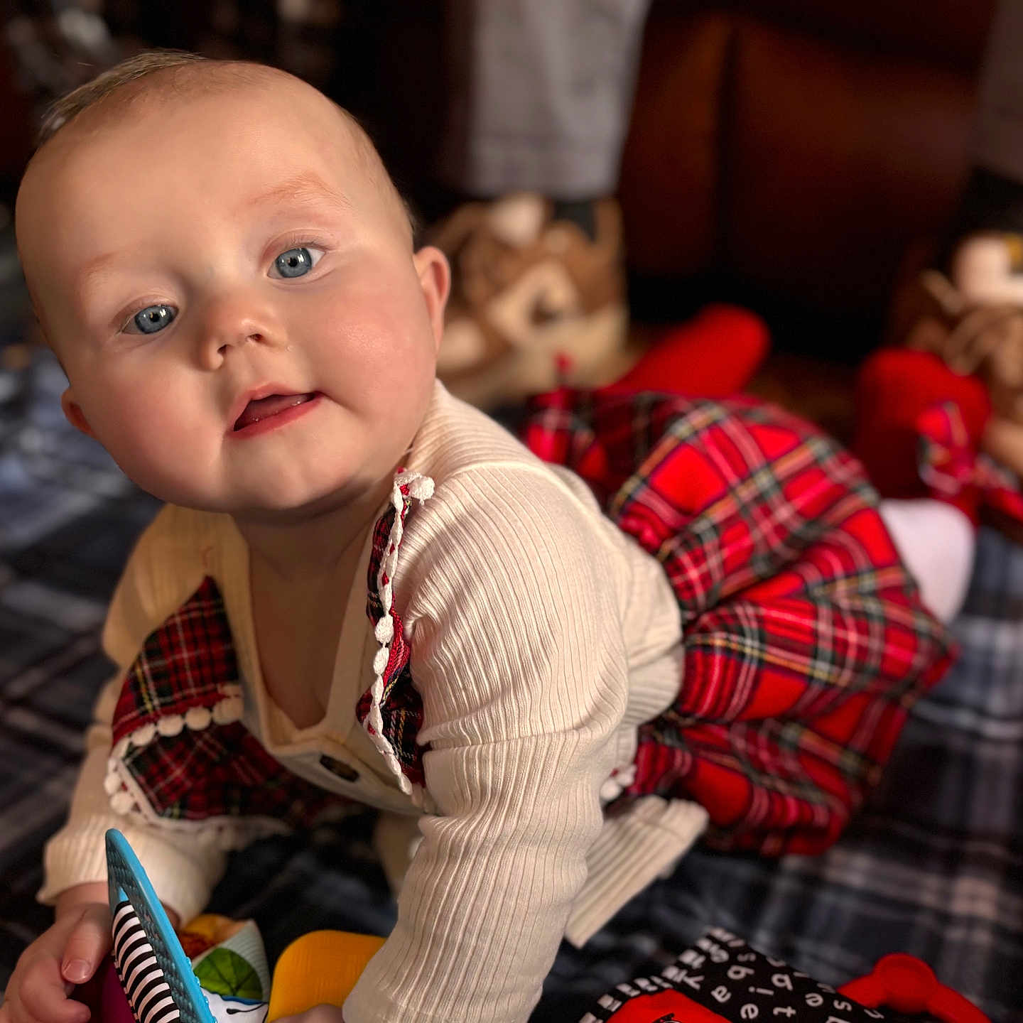Mclane joined the competition — help win amazing prizes! baby, blanket, blue_eyes, boots, child, couch, crawling, cream_sweater, curious, cute, face, floor, indoors, infant, person, plaid_dress, portrait, smiling, soft_lighting, toy