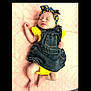 adorable, baby, child, cute, denim_dress, headband, indoors, infant, lying_down, newborn, peaceful, pink_blanket, portrait, quilted_blanket, sleeping, small_feet, small_hands, soft_lighting, sunflower_pattern, yellow_clothing