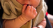 Axel joined the competition — help win amazing prizes! baby, newborn, infant, child, portrait, face, hands, finger, sucking_finger, blanket, wrapped, cozy, seated, close_up, indoor, soft_lighting, warm_tones, photography, baby_clothing, peaceful