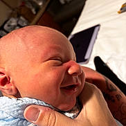 Axel is registered to the contest to win money with this photo: newborn, baby, infant, child, face, portrait, sleeping, eyes_closed, smiling, indoors, hand, holding, cradled, blue_clothing, skin, close_up, parenting, family, home, photography