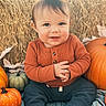 Rowen joined the competition — help win amazing prizes! baby, child, pumpkin, orange_sweater, hay, fall, autumn, smile, cute, sitting, outdoor, seasonal, festive, portrait, person, cozy, warm_clothing, nature, holiday, background