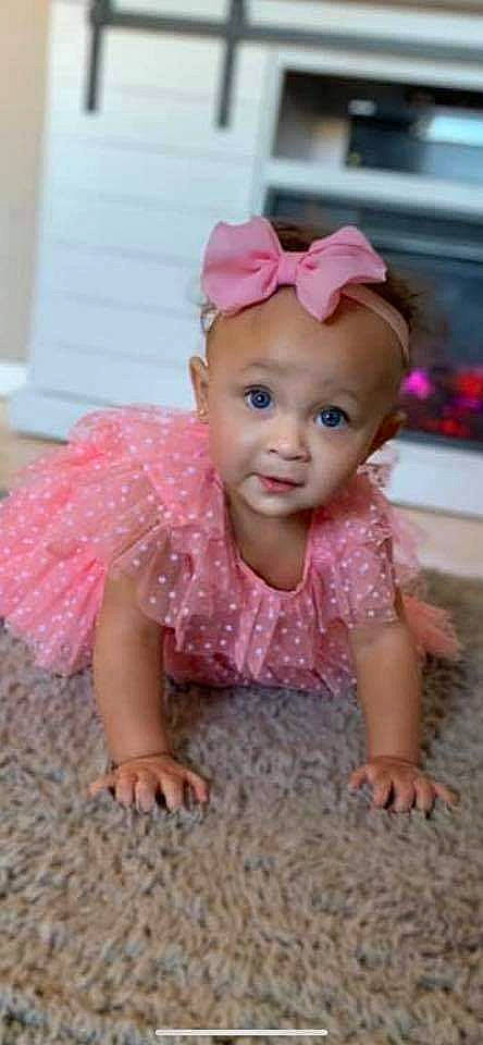 Rihanna is registered to the contest to win money with this photo: baby, baby_laughing, baby_toddler_clothing, cheek, child, clothing, costume, dress, fashion_accessory, hair_accessory, headband, headgear, headpiece, person, pink, product, skin, smile, toddler