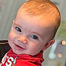 baby, background_blur, child, cute, expression, eyes, face, hair, hand, happy, head, holding, indoor, infant, person, portrait, red_shirt, skin, smiling, toddler