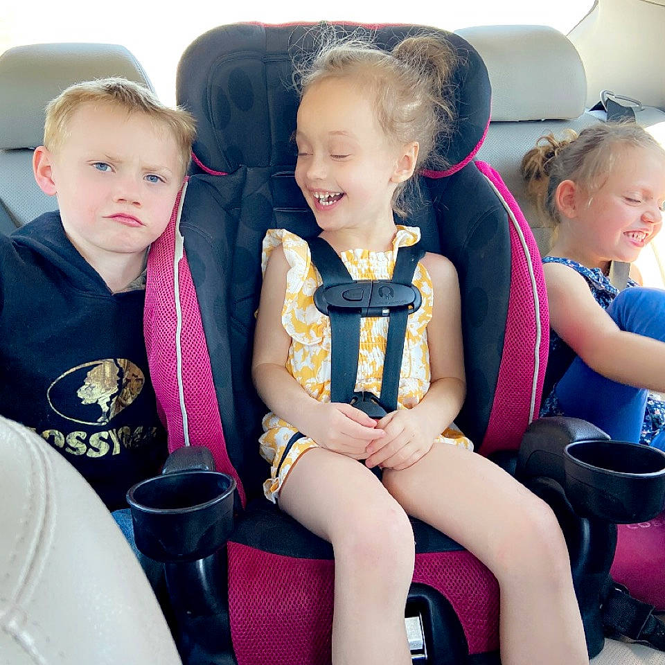 Elizabeth is registered to the contest to win money with this photo: auto_part, baby_toddler_clothing, blond, car_seat, chair, child, clothing, dress, fun, happy, head, joy, lap, person, seat_belt, sharing, sitting, skin, smile, steering_wheel