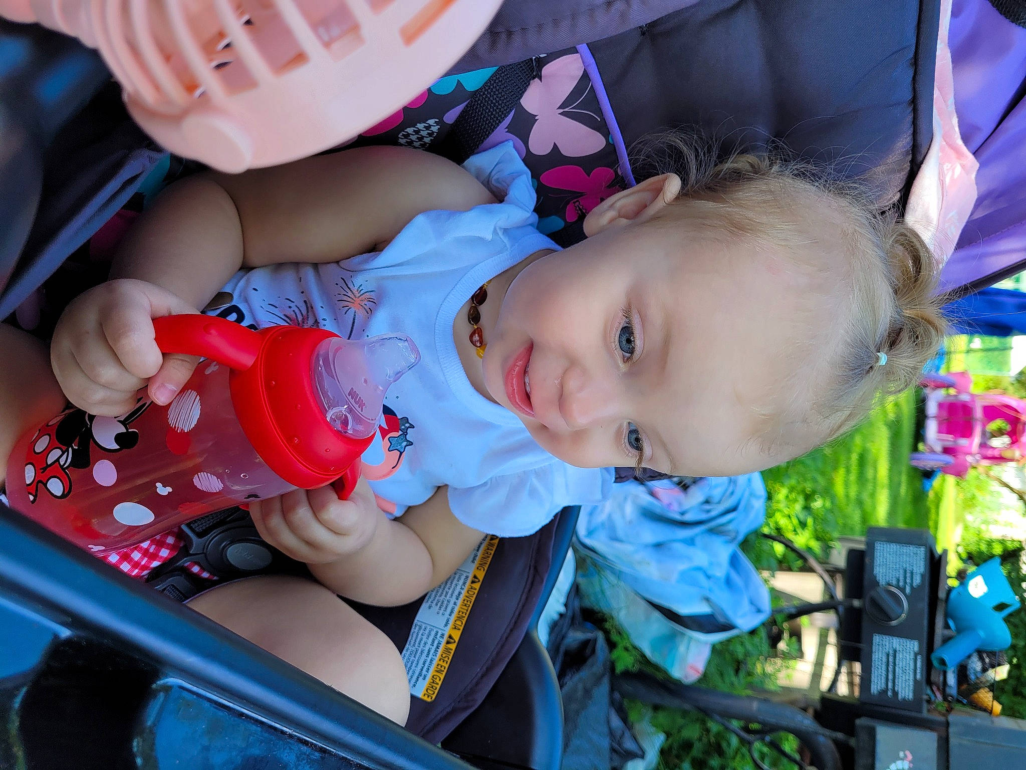 Athena is registered to the contest to win money with this photo: baby, baby_carriage, baby_products, baby_toddler_clothing, child, comfort, electric_blue, eye, fun, grass, happy, human_body, leisure, mouth, person, sitting, skin, smile, toddler, tree