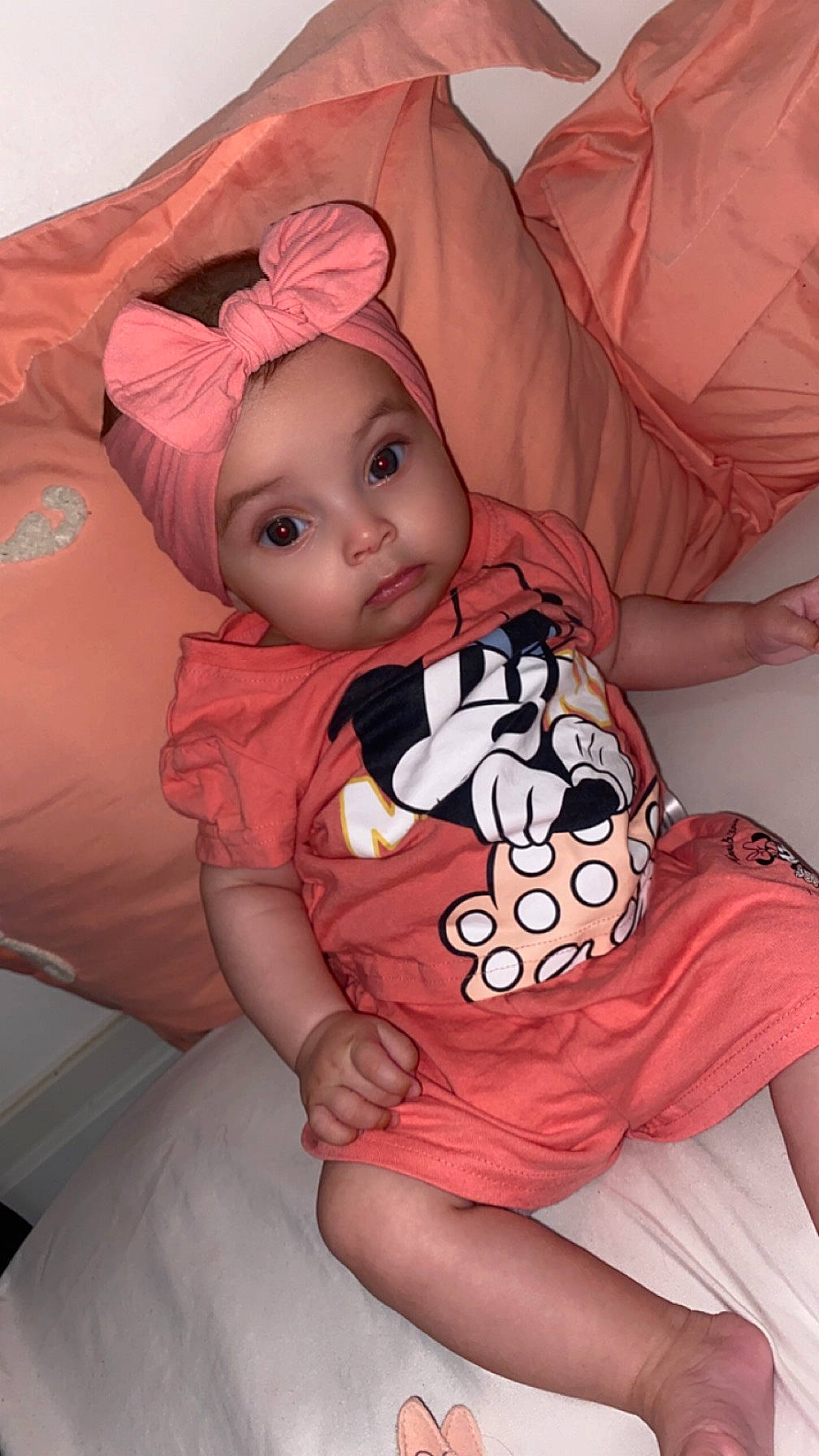 Yliana participe au concours pour gagner de l'argent avec cette photo : baby, baby_toddler_clothing, cheek, child, comfort, facial_expression, finger, happy, headwear, human_body, linens, mouth, person, pink, sitting, skin, sleeve, t_shirt, textile, thigh