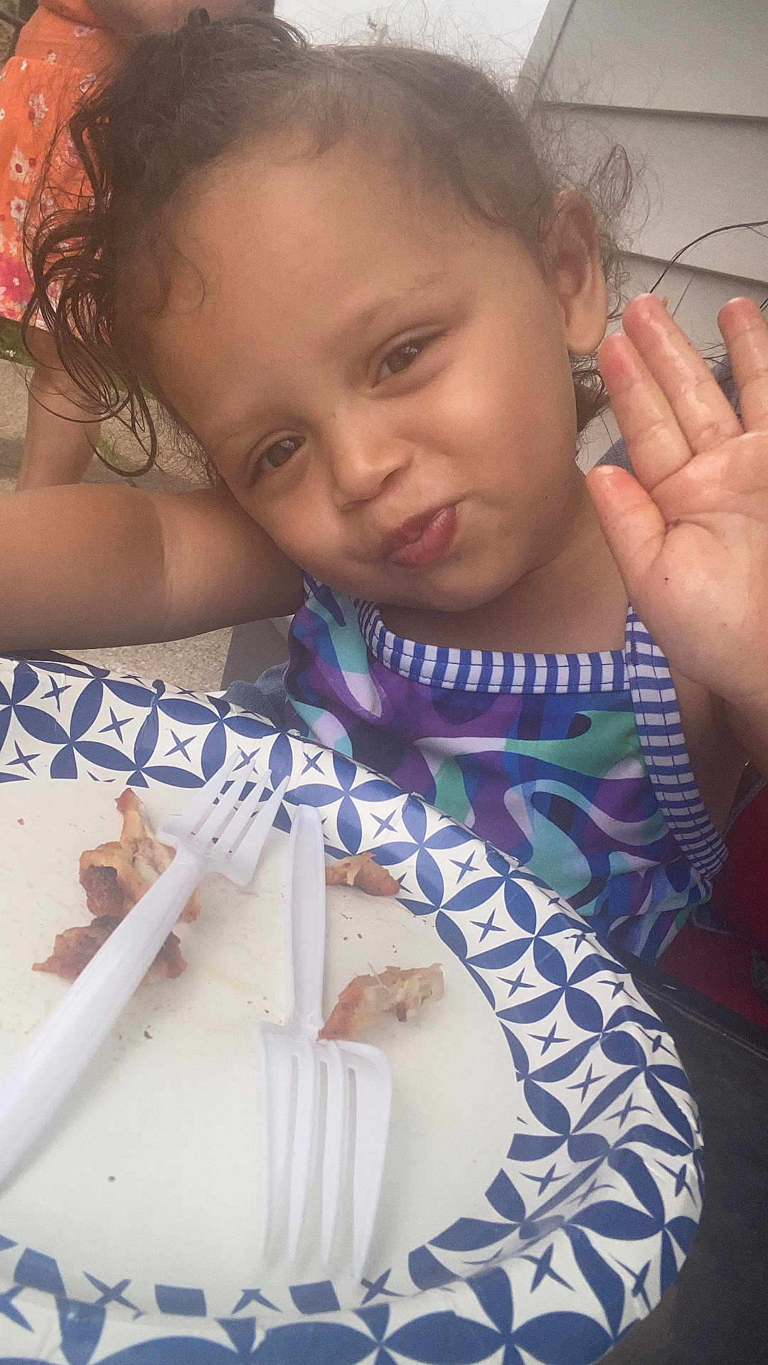 Anayaaracely Ginorio is registered to the contest to win money with this photo: child, curly_hair, waving, smiling, paper_plate, plastic_forks, food_leftovers, outdoor, casual, meal, colorful_clothing, person, face, happy, table, summer, daylight, closeup, fun, cute