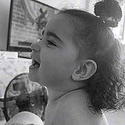 Gioia Maria participe au concours pour gagner de l'argent avec cette photo : arm, black_and_white, bun, child, closeup, curly_hair, fan, furniture, hair, happy, indoor, laughing, person, profile, room, skin, smiling, tattoo, television, toddler