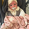 baby, infant, pacifier, car_seat, blanket, headwrap, sweater, pink, cream, cute, wide_eyes, cozy, child, indoor, seatbelt, soft, warm, comfort, toddler, portrait