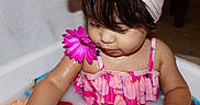 Amaia is registered to the contest to win money with this photo: toddler, child, bath, milk_bath, flower, pink, swimsuit, water, toy, head_towel, skin, cute, indoor, play, colorful, baby, fun, summer, portrait, wet