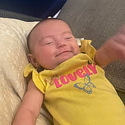 Taylynn joined the competition — help win amazing prizes! baby, child, yellow_shirt, butterfly, smile, couch, cushion, arm, clothing, infant, face, person, indoor, cute, happy, blur, relaxing, lying_down, skin, head