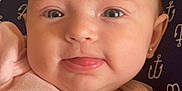 Taylynn joined the competition — help win amazing prizes! baby, face, tongue, pink_clothing, minnie_mouse, earrings, indoor, close_up, expression, child, soft_lighting, wicker_shelf, fabric, anchor_pattern, cute, person, head, infant, smiling, portrait