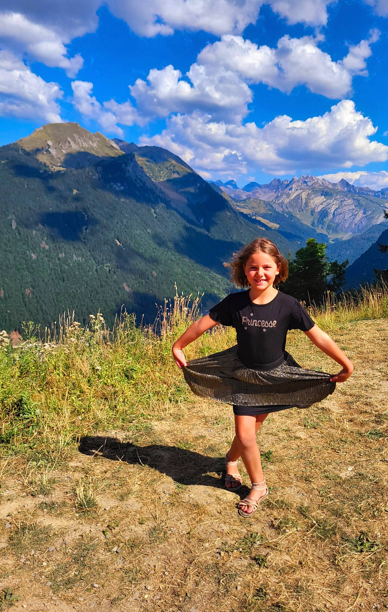 Celena participe au concours pour gagner de l'argent avec cette photo : blue, cloud, grass, grassland, happy, highland, joy, landscape, leisure, mountain, mountainous_landforms, natural_environment, natural_landscape, people_in_nature, person, plain, plant, shoe, sky, smile