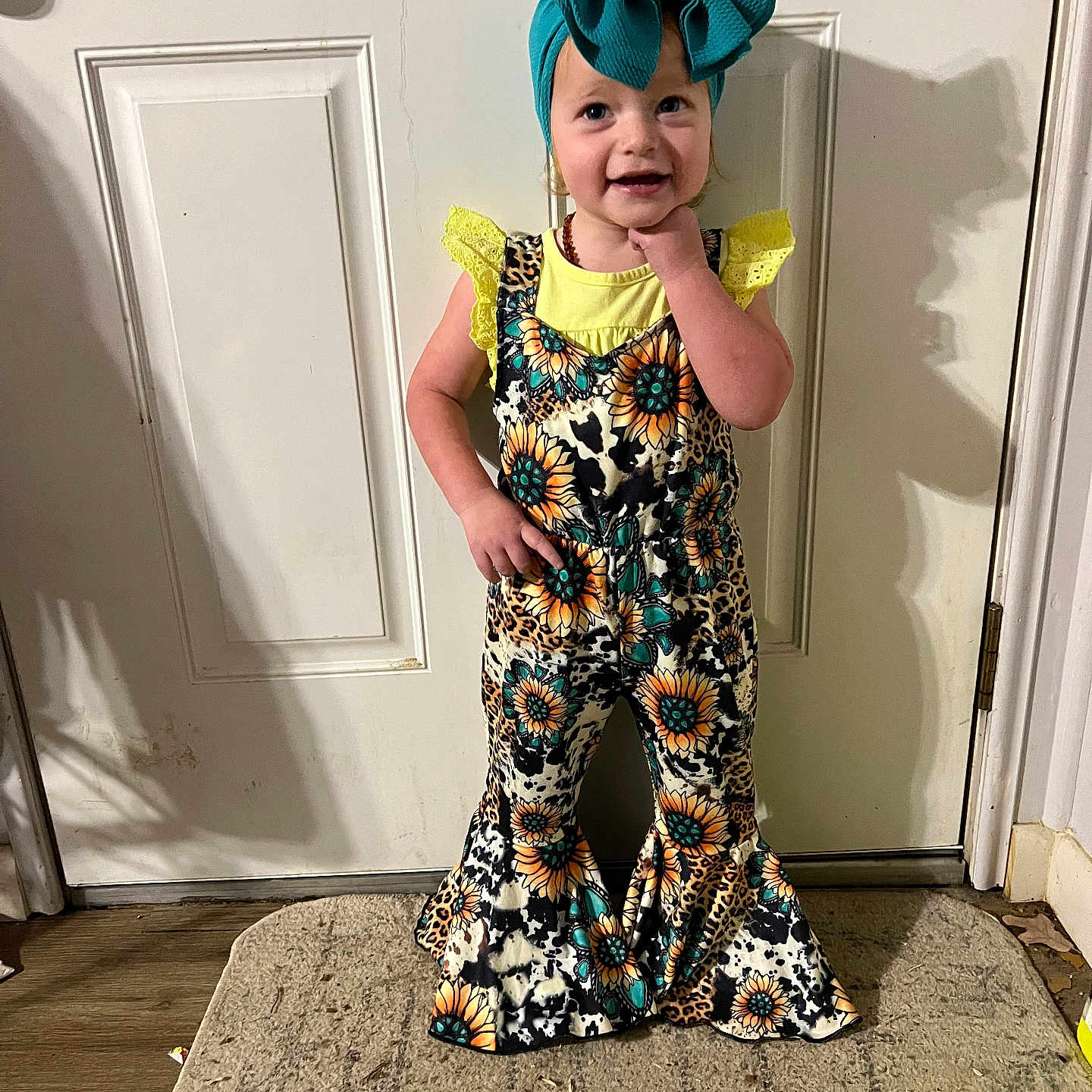 Tatum joined the competition — help win amazing prizes! bow, carpet, child, cute, door, fashion, floor, floral, happy, headband, indoor, lace, pants, patterned_clothing, person, portrait, smiling, standing, toddler, yellow