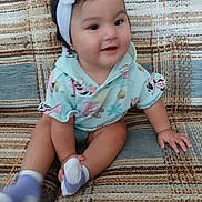 Penelope joined the competition — help win amazing prizes! baby, child, sitting, couch, headband, flower, clothing, pattern, hand, foot, smile, infant, cute, indoors, person, sock, fabric, furniture, happy, portrait