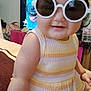 Penelope joined the competition — help win amazing prizes! baby, child, sunglasses, yellow, striped_clothing, cute, indoor, sitting, face, headwear, hat, smile, plush, arm, leg, person, furniture, television, reflection, cozy