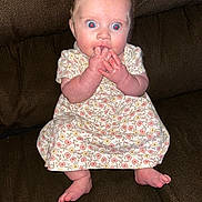 Maria joined the competition — help win amazing prizes! baby, child, infant, dress, floral_pattern, sitting, couch, fingers_in_mouth, red_eye, wide_eyes, cute, indoors, person, footwear_off, barefoot, expression, skin, hands, legs, seat