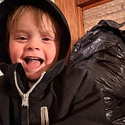 Levi joined the competition — help win amazing prizes! child, smiling, hoodie, black_clothing, happy, indoor, face, young_child, tongue_out, zipper, wooden_wall, shelf, household_items, curtain, person, portrait, casual, joyful, closeup, cute