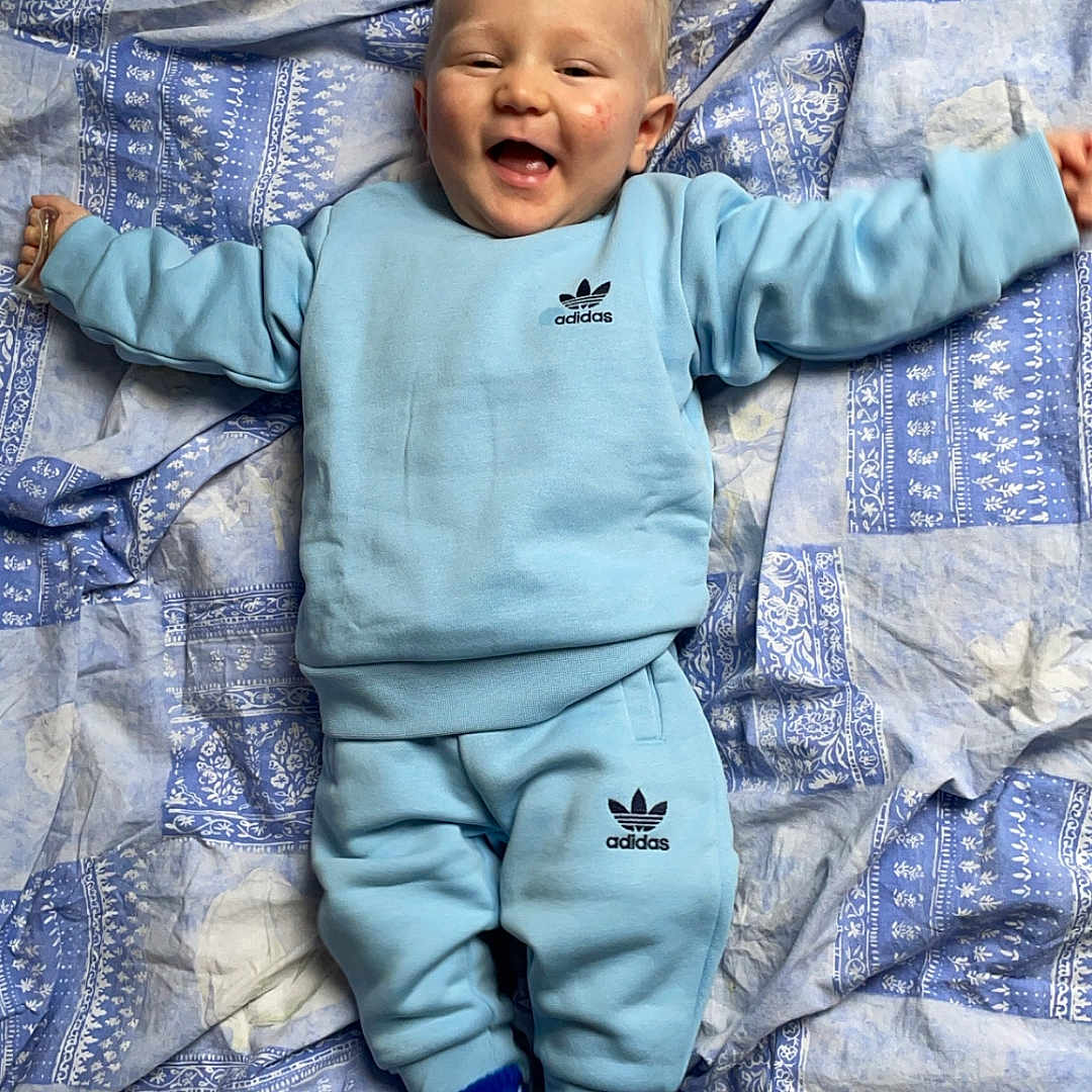 Ayden a rejoint le concours — aidez-le/la à gagner de superbes lots ! baby, bed, bedroom, blanket, clothing, face, furniture, glove, happy, head, indoors, laughing, newborn, pants, person, photography, portrait, quilt, room, smile
