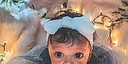 Caleigh joined the competition — help win amazing prizes! baby, child, christmas, holiday, lights, headband, bow, cute, curious, indoors, decorations, festive, cozy, warm, soft, white, dark_sweater, face, hands, floor