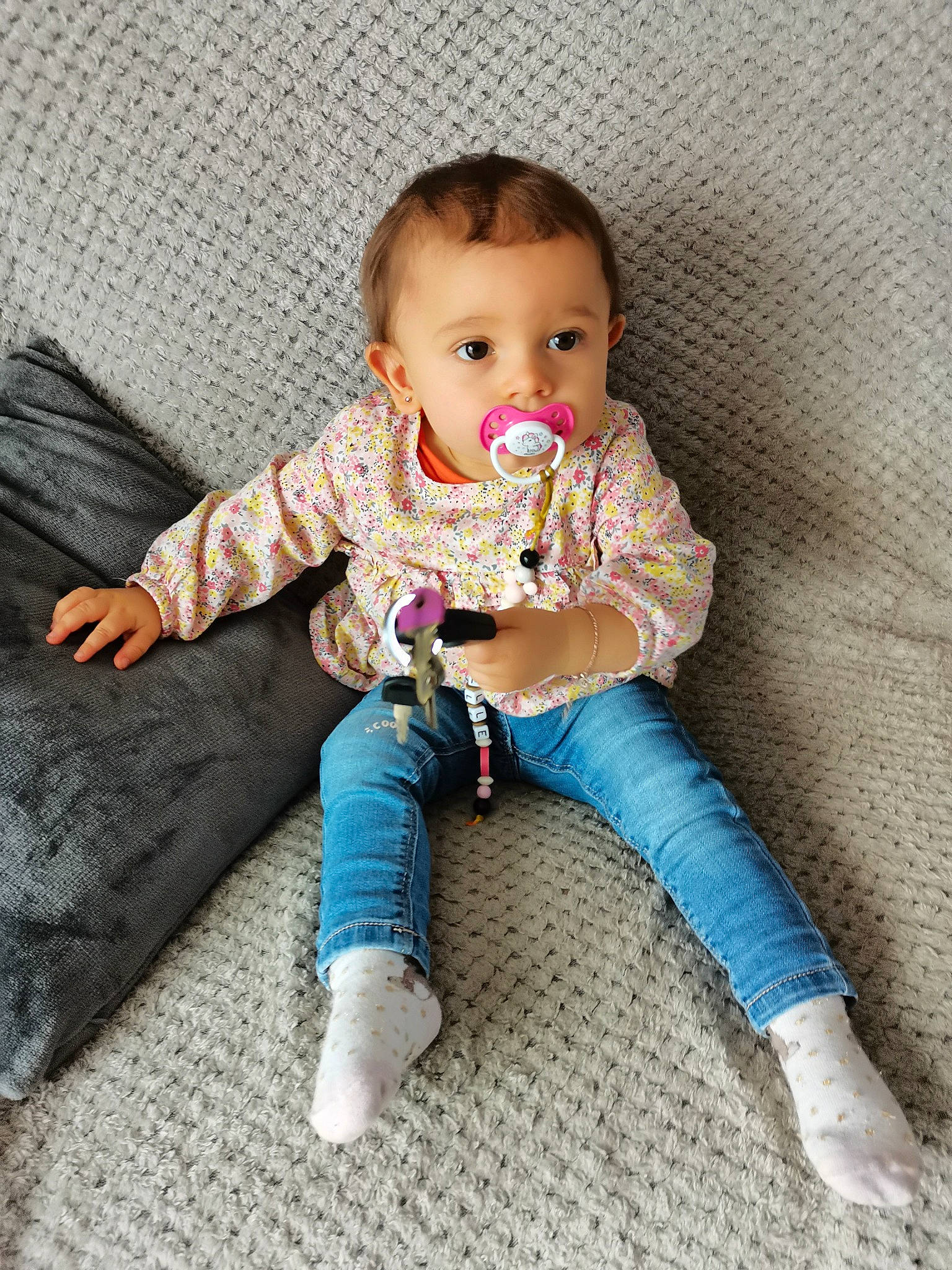 Ennaëlle a rejoint le concours — aidez-le/la à gagner de superbes lots ! baby, baby_toddler_clothing, barefoot, cheek, child, comfort, face, flooring, foot, head, human_body, human_leg, knee, linens, pattern, person, sitting, sleeve, sock, thigh