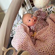 Adelyn joined the competition — help win amazing prizes! baby, blanket, crochet, playpen, toy, plush_toy, infant, child, indoor, curious, pink, floral_pattern, face, looking_up, soft_toys, hand, cozy, newborn, lying_down, colorful