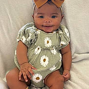 Ivy joined the competition — help win amazing prizes! baby, child, smile, bow, headband, socks, green_outfit, daisy_pattern, sitting, blanket, indoors, cute, infant, happy, portrait, clothing, footwear, cozy, young_child, person