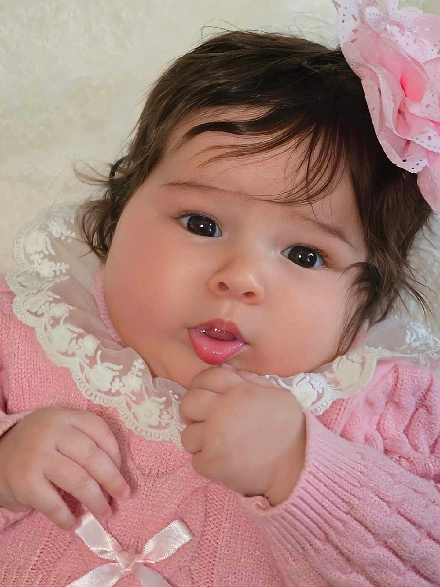 Ashley joined the competition — help win amazing prizes! baby, child, face, portrait, pink_clothing, lace, headband, flower, cute, chubby_cheeks, hand, infant, soft_light, closeup, adorable, young_child, skin, dark_hair, expression, indoor