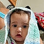 Rain is registered to the contest to win money with this photo: baby, child, crochet_blanket, indoor, portrait, colorful_clothing, hand, wall_art, tropical_painting, furniture, person, cute, young_child, expression, face, seated, blanket, soft_texture, home, decor