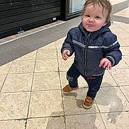 Raphaël participe au concours pour gagner de l'argent avec cette photo : active, brown_shoes, casual_clothing, child, curly_hair, cute, floor_tiles, fun, indoor, jacket, person, playful, shopping_mall, small_person, smiling, toddler, tongue_out, walking, wet_hair, young_child