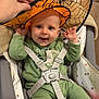 London participe au concours pour gagner de l'argent avec cette photo : baby, child, high_chair, orange_hat, witch_hat, spiderweb_pattern, green_onesie, smiling, happy, indoor, toy, yellow_ball, pacifier, hand, straps, seat, fabric, face, cute, playful