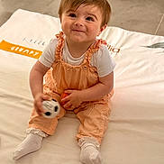 Camellia participe au concours pour gagner de l'argent avec cette photo : baby, child, smiling, sitting, toy, soccer_ball, orange_ball, white_socks, overalls, hair_bow, blanket, indoor, cute, playful, portrait, infant, happy, clothing, floor, person