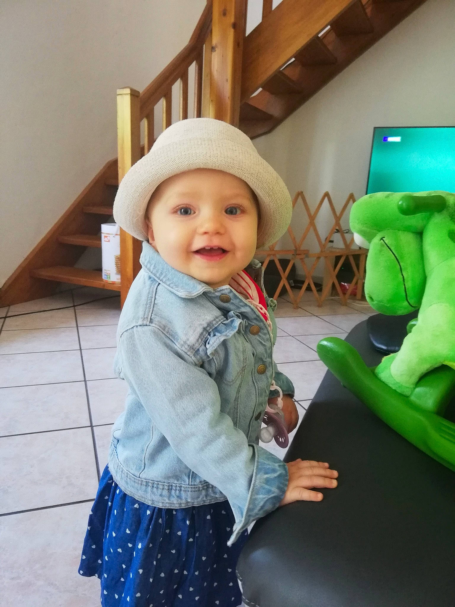 Ava a rejoint le concours — aidez-le/la à gagner de superbes lots ! baby, baby_toddler_clothing, child, comfort, facial_expression, flooring, fun, green, happy, head, headwear, outerwear, pattern, person, picture_frame, plaid, skin, sleeve, smile, television
