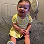 toddler, child, smiling, yellow_dress, sitting, bed, colorful_shoes, indoor, fan, closet, happy, person, short_hair, cute, playful, young_child, furniture, home, portrait, casual