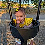 Madeleine is registered to the contest to win money with this photo: toddler, child, swing, playground, yellow_clothing, yellow_bow, outdoor, tree, sunset, shadow, smile, cute, baby, face, person, seat, metal_chains, nature, park, fun