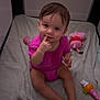 Madeleine joined the competition — help win amazing prizes! baby, child, pink_onesie, playpen, blanket, toy, plush_toy, rattle, infant, sitting, indoor, cute, smiling, face, hand, foot, person, young_child, floor, soft_toy