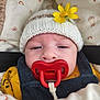 Charlie participe au concours pour gagner de l'argent avec cette photo : baby, pacifier, knitted_hat, flower, blanket, yellow, red, closeup, face, child, sleepy, cute, warm_clothing, infant, cozy, person, portrait, fabric, pattern, soft