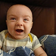 Asher is registered to the contest to win money with this photo: baby, smiling, happy, face, child, blanket, blue, striped_clothing, sitting, portrait, infant, cute, cozy, indoors, young_child, human, skin, head, eyes, mouth