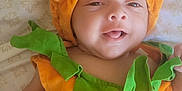 Hugo joined the competition — help win amazing prizes! baby, infant, costume, pumpkin, orange, green, smile, face, cute, child, bedspread, pattern, soft, clothing, lying_down, happy, festive, holiday, portrait, indoors