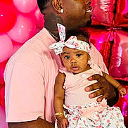 Serenity joined the competition — help win amazing prizes! baby, child, man, father, holding, pink_shirt, headband, floral_dress, bracelet, earrings, balloons, party, celebration, portrait, indoor, smiling, happy, family, people, skin