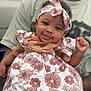 Serenity is registered to the contest to win money with this photo: baby, child, smile, flower_dress, headband, adult, hand, car, outdoor, portrait, cute, happy, person, clothing, holding, skin, face, toddler, accessory, casual
