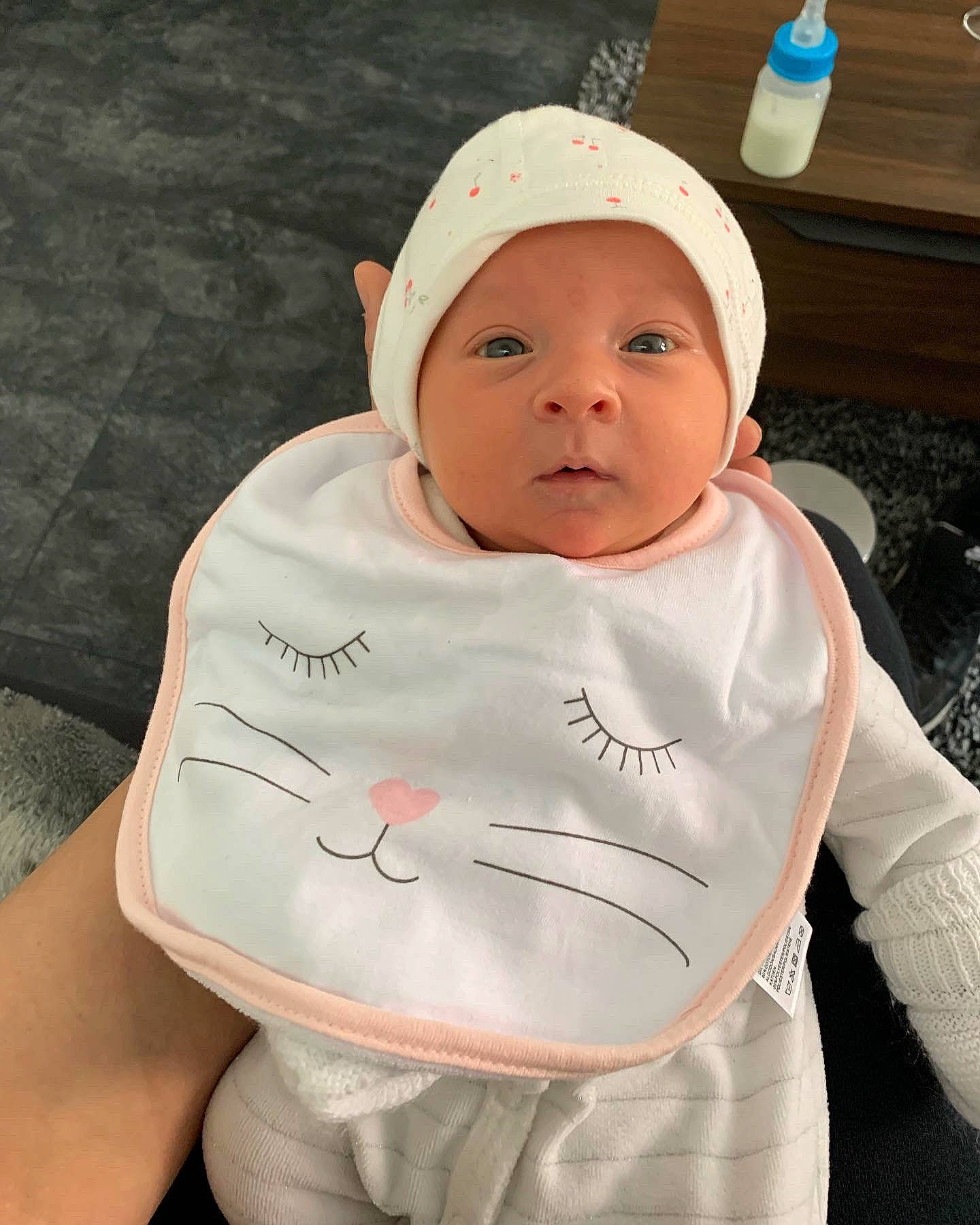 Julia a rejoint le concours — aidez-le/la à gagner de superbes lots ! baby, baby_toddler_clothing, baseball_cap, bib, cap, chest, child, face, gesture, happy, hat, headgear, headwear, hoodie, person, personal_protective_equipment, sitting, sleeve, sportswear, t_shirt