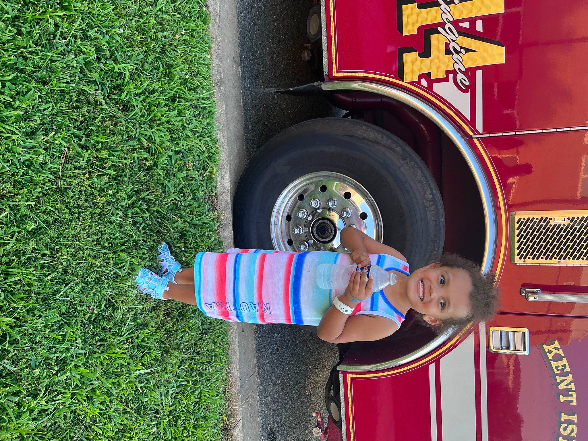 Caylee is registered to the contest to win money with this photo: asphalt, automotive_design, automotive_exterior, automotive_lighting, automotive_tire, automotive_wheel_system, bumper, commercial_vehicle, fender, grass, hat, joy, motor_vehicle, person, tire, tire_care, toddler, tread, truck, vehicle